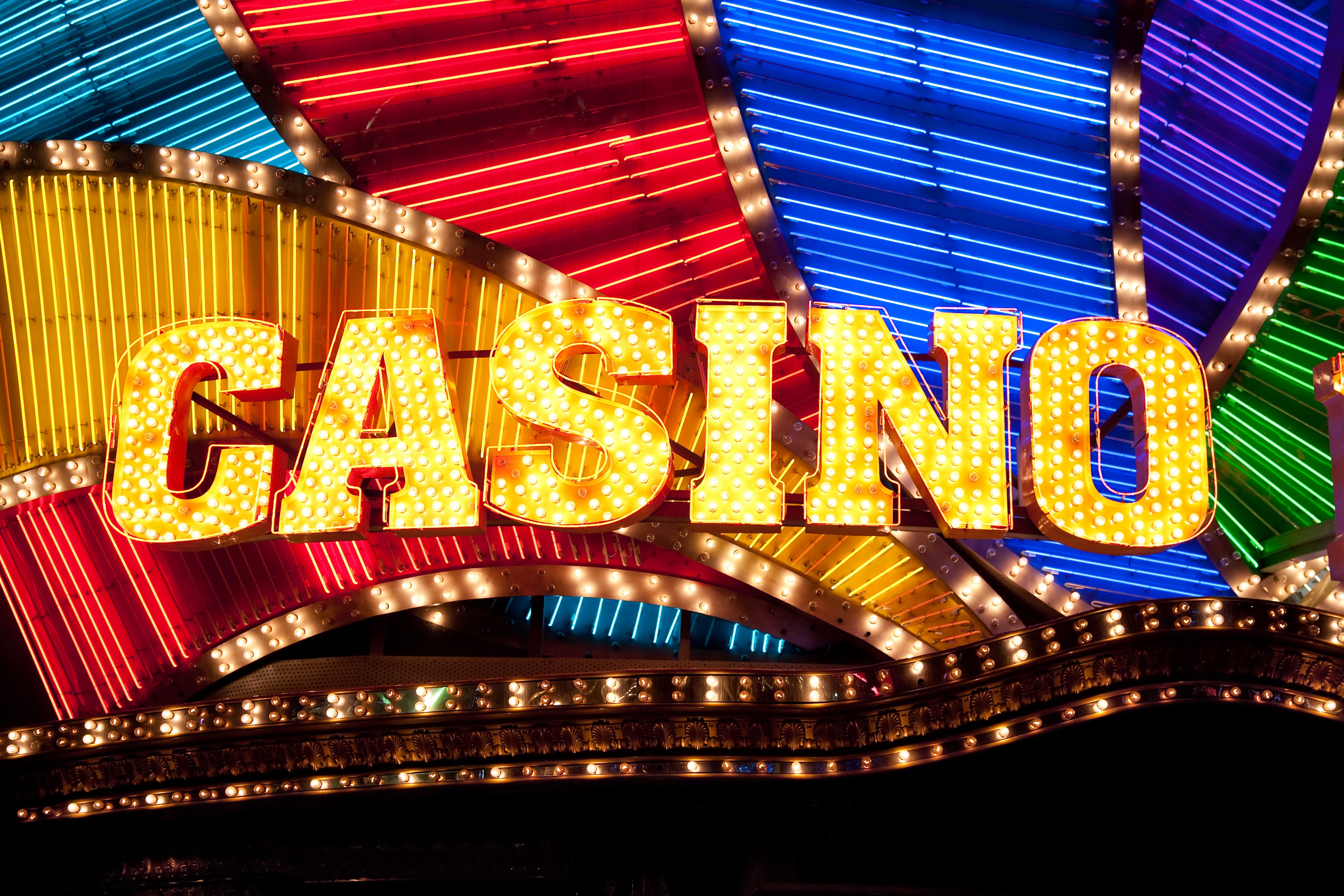 A dynamic graphic of a hand receiving cash from a smartphone screen with casino chips in the background.